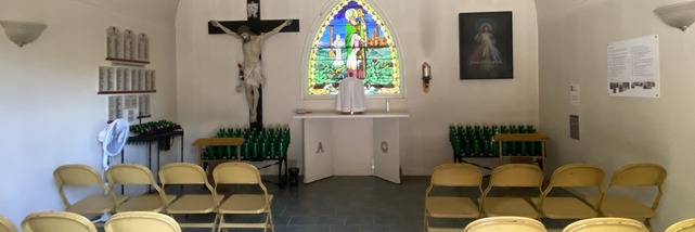 Inside the St. Patrick Votive Chapel, with a crucifix and stained-glass window.