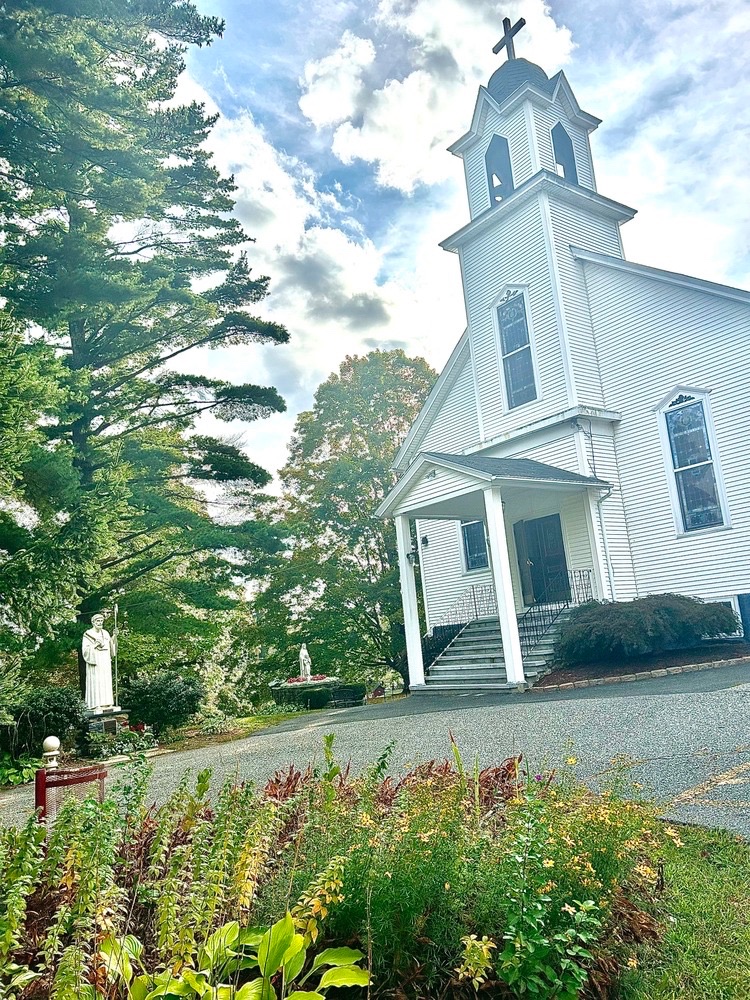 The white clapboard church on the shrine grounds on a summer day.